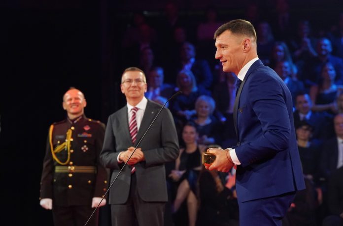 Valsts prezidents Edgars Rinkēvičs (no kreisās) un pludmales volejbolists Mārtiņš Pļaviņš ar saņemto 