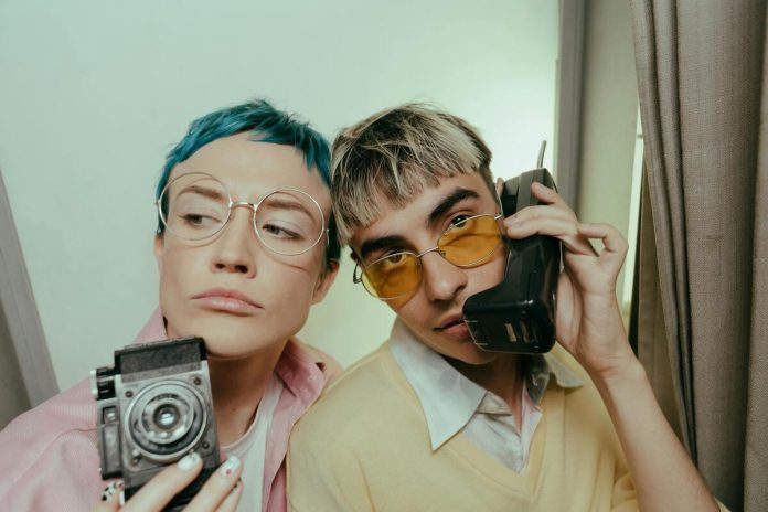 Jaunieši, brilles, telefons, fotoaparāts